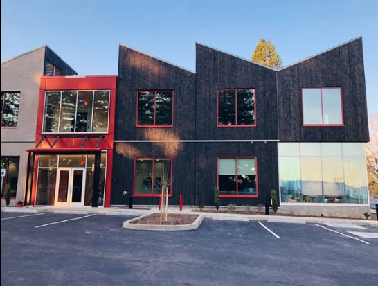 Modern building with red accents and parking lot